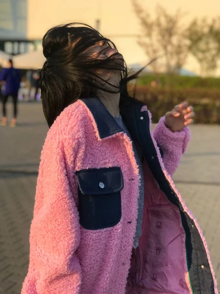 Pembe ceketli genç bayan, Polonya, Varşova 'daki ticaret merkezinin yanındaki altın saat sokakta vuruldu..