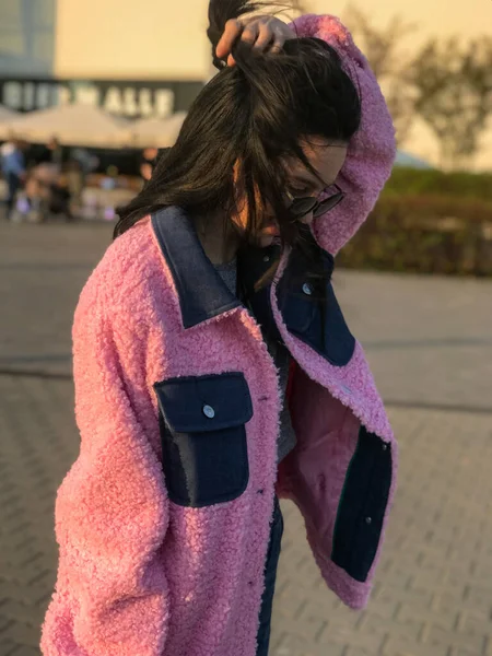 Pembe ceketli genç bayan, Polonya, Varşova 'daki ticaret merkezinin yanındaki altın saat sokakta vuruldu..