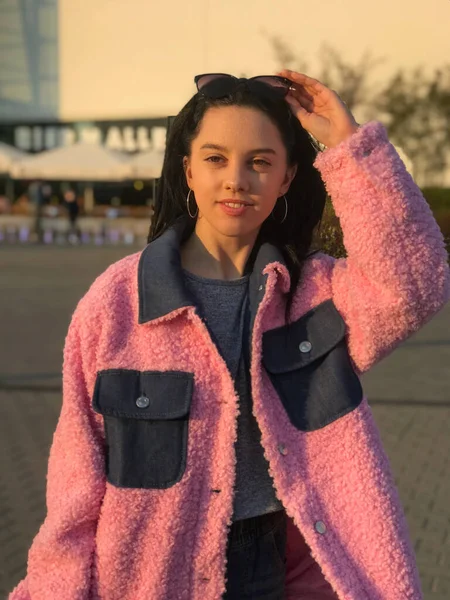 Pembe ceketli genç bayan, Polonya, Varşova 'daki ticaret merkezinin yanındaki altın saat sokakta vuruldu..