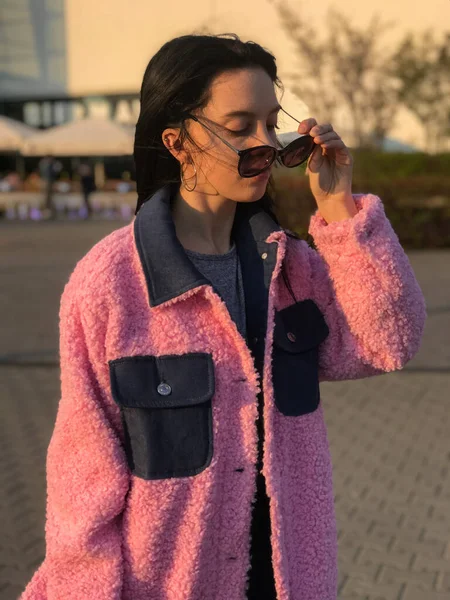 Pembe ceketli genç bayan, Polonya, Varşova 'daki ticaret merkezinin yanındaki altın saat sokakta vuruldu..