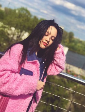 Wisla Nehri manzaralı Varşova Üniversitesi Kütüphanesi 'nin çatısındaki pembe ceketli genç bayan.