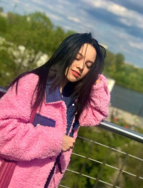 Wisla Nehri manzaralı Varşova Üniversitesi Kütüphanesi 'nin çatısındaki pembe ceketli genç bayan.