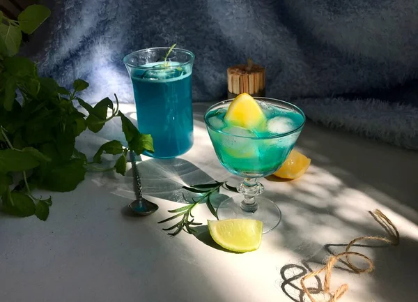 바탕에 얼음이 유리잔에 음료수를 넣는다 로즈마리 창문에서 나오는 햇빛을 숟가락을 — 스톡 사진