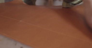 Tanner 'lar deri bir çarşaf üzerinde. Usta bir parça deriyi düzleştirir.