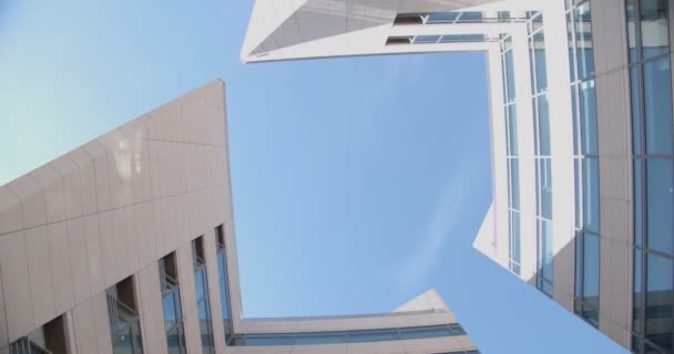 Dos edificios de centros de negocios contra el cielo azul, vista inferior. — Vídeos de Stock