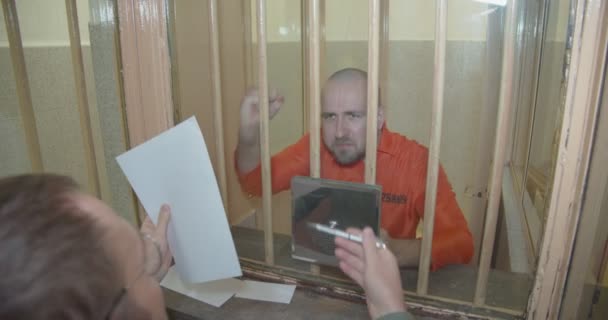 De advocaat vraagt de gevangene om de papieren te tekenen, de gevangene weigert. — Stockvideo