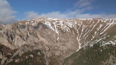 Güneşli bir günde tepesinde karla yüksek ve güzel bir dağa doğru uzun bir uçuş.