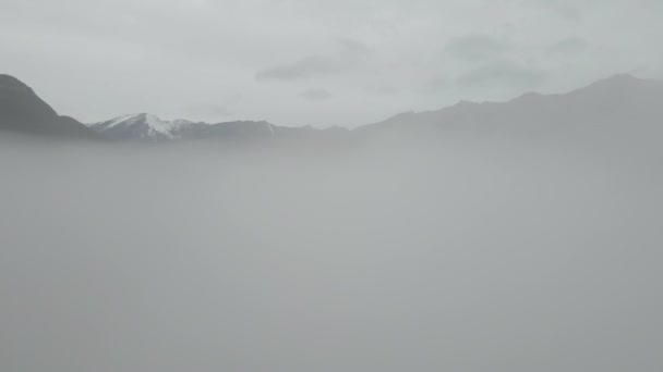 Przelot przez chmury w kierunku wysokoośnieżonych gór — Wideo stockowe