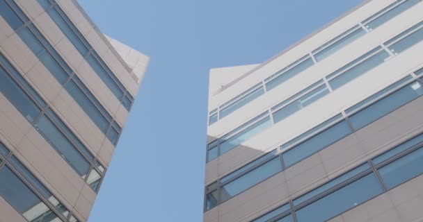 Clădiri de birouri din beton și sticlă de culoare deschisă, vedere de jos — Videoclip de stoc