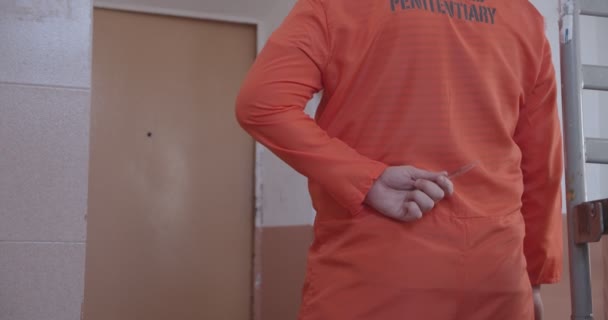 Gevangene in een gevangeniscel bereidt zich voor om een gevangenisbewaker aan te vallen. — Stockvideo