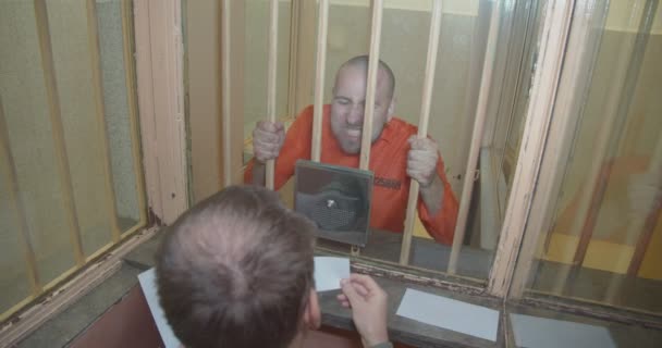 Rozzlobený vězeň řve na právníka a mlátí rukama do mříží ve vězení. — Stock video