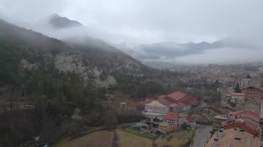 Dağların yanındaki küçük sevimli kasaba, drone manzaralı.