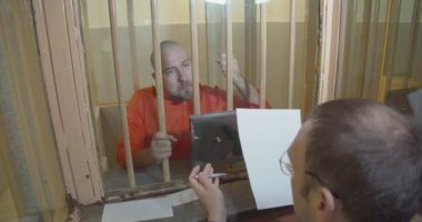 Avukat, sanıkla hapishanedeki müzakere odasında tartışıyor.