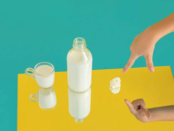 ケフィアミルクと子供たちのカップは ケフィア菌に手をポイントします 黄色の背景に鏡の中に映し出されるミニマルな乳製品の自然な健康食品シーン 消化器系飲料またはプロバイオティクスソースのアイデア — ストック写真