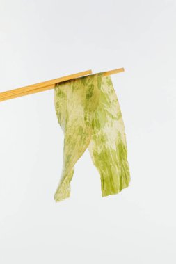 İzole edilmiş pastel beyaz arka planda yosun ve yemek çubukları. Minimum konsept. Makrobiyotik mutfak. Omega-3, sodyum, kalsiyum, iyot, tiamin, niasin gibi doğal deniz ürünleri.