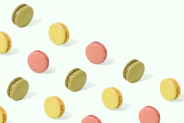 Renkli, lezzetli Fransız kurabiyeleri izole edilmiş pastel beyaz arka plan ve fotokopi alanı. Not kartı konsepti. Soyut şekerleme dokusu. Güneş ve gölgeler. Minimum fırın besin kalıbı.