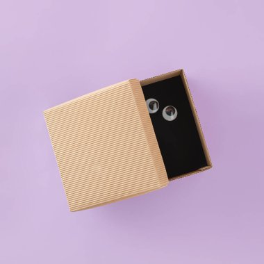 Karton kutuyu aç ve izole edilmiş mor arka planda korkmuş gözler. Minimum düzlük. Yaratıcı kart. Koronavirüs korkusu, sosyal uzaklık, yalnızlık ya da pandemik anksiyete. Covid-19 salgını sırasında karantina.