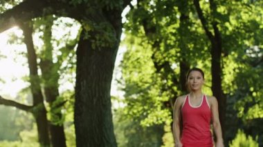 güzel kız durur sırasında germe için parka koşmak.