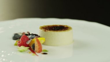Creme brulee tatlısı beyaz plaka üzerinde çilek ile.