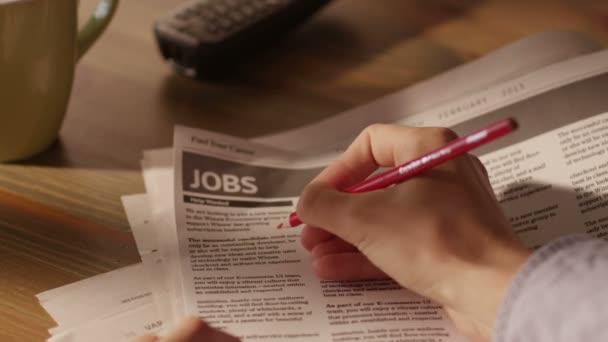 Hombre buscando trabajo en un periódico y marcando publicidad usando lápiz rojo — Vídeos de Stock