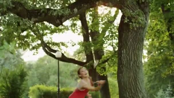 Όμορφο κορίτσι παίζοντας μπάντμιντον στη φύση. — Αρχείο Βίντεο