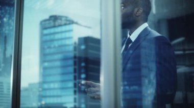 Siyahi İşadamı Ofiste Akıllı Telefon Kullanıyor