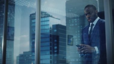 Siyahi İşadamı Ofiste Akıllı Telefon Kullanıyor