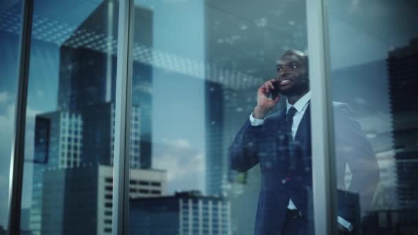 Черный бизнесмен с помощью смартфона в офисе — стоковое видео