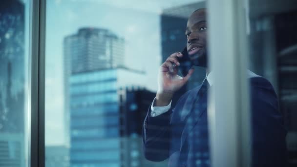 Homme d'affaires noir utilisant le téléphone intelligent dans le bureau — Video