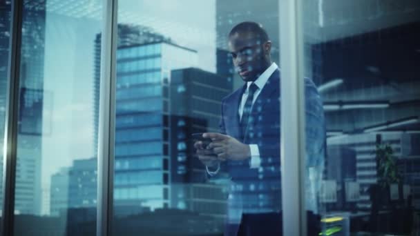 Zwarte zakenman met behulp van Smartphone in Office — Stockvideo
