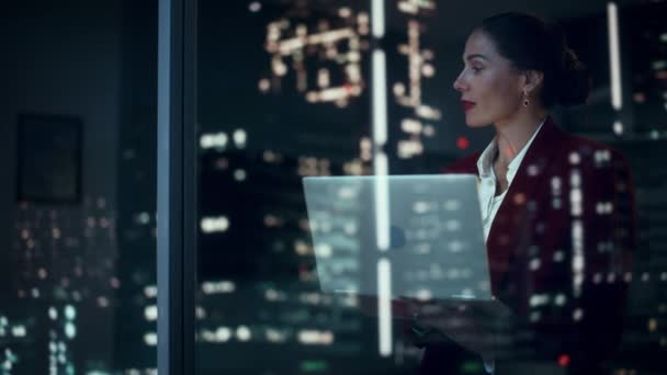 Donna d'affari che utilizza nel computer portatile nella finestra dell'ufficio — Video Stock