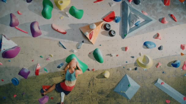 Escalador practicando en el muro de escalada interior — Vídeos de Stock