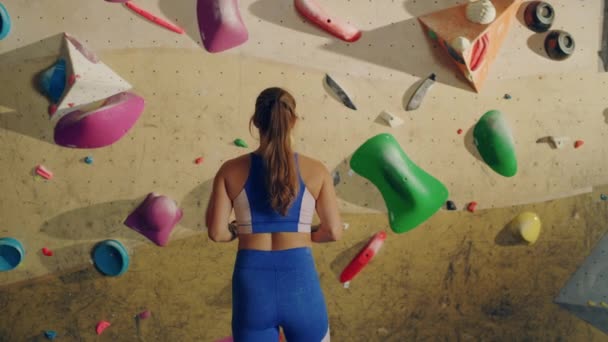 Atleta feminina praticando na parede de escalada interior — Vídeo de Stock