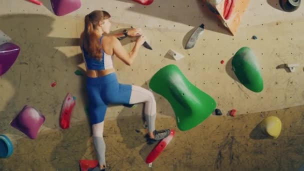 Жіночий спортсмен, практикуючись у приміщенні, піднімається на стіну — стокове відео