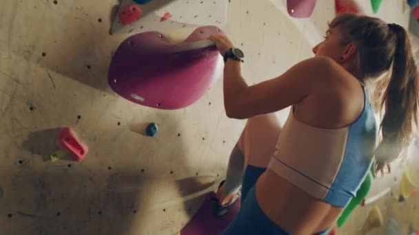 Sportivul de sex feminin practicând pe peretele de cățărare interior — Videoclip de stoc