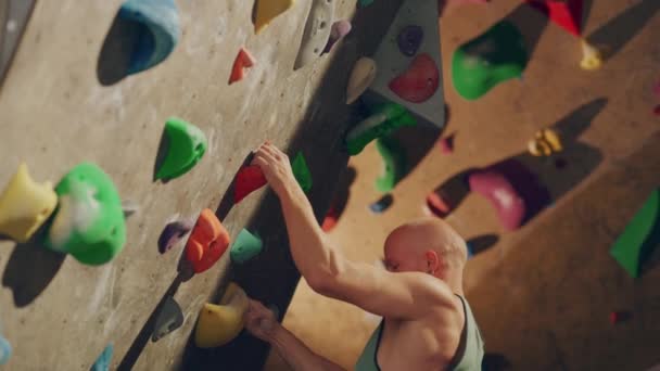 Escalador practicando en el muro de escalada interior — Vídeos de Stock