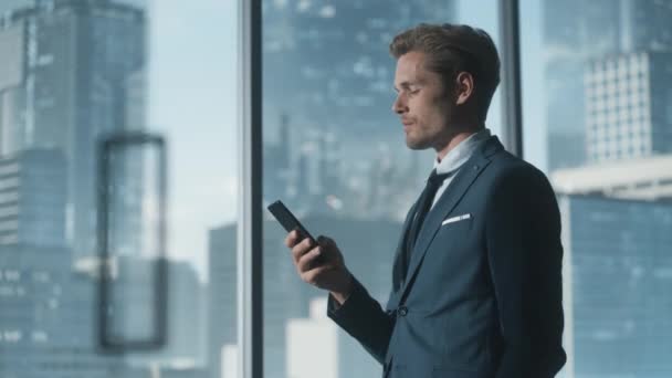 Бизнесмен использует смартфон в Office — стоковое видео