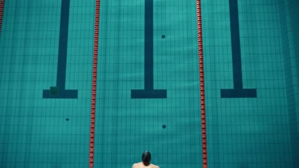 Зверху вниз чоловічий плавець стрибає в басейн — стокове відео