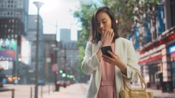 Японская женщина использует смартфон на Сити-стрит — стоковое видео