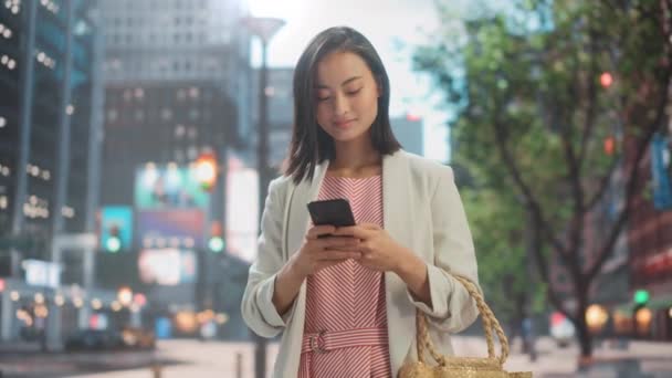 Japanese Female Uses Smartphone on City Street — Stock Video