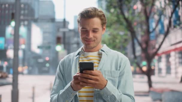 Knappe man gebruikt Smartphone op City Street — Stockvideo