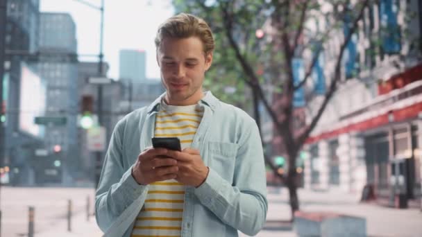 Hombre guapo utiliza Smartphone en la calle City — Vídeo de stock