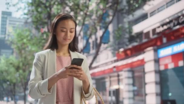 Японська жінка користується смартфоном на вулиці Сіті — стокове відео