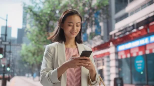 Japanerin nutzt Smartphone auf der Straße — Stockvideo