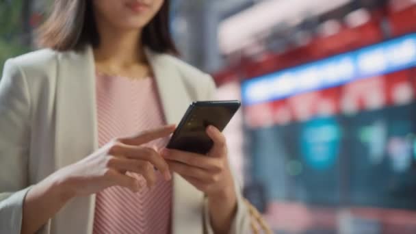 Japansk kvindelig bruger Smartphone på City Street – Stock-video