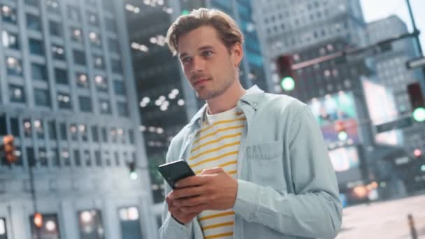 Красавчик пользуется смартфоном на Сити-стрит — стоковое видео