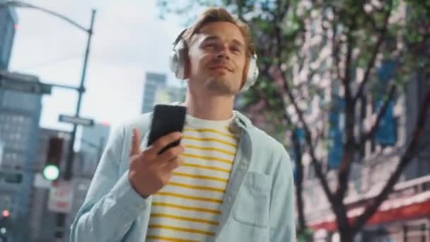Smuk mand lytter musik på Smartphone på City Street – Stock-video