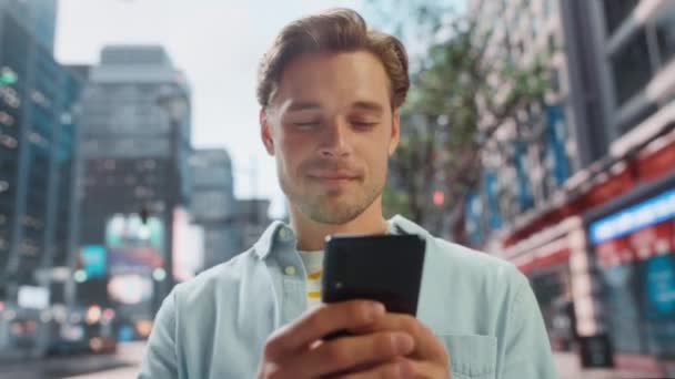 Hombre guapo utiliza Smartphone en la calle City — Vídeo de stock