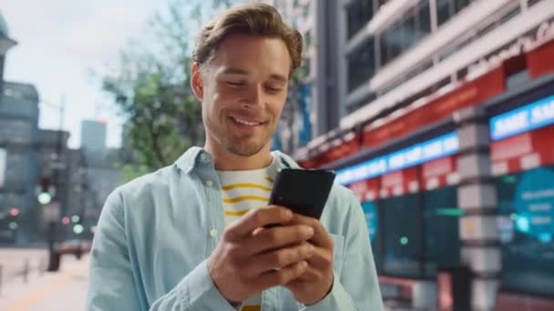 Hombre guapo utiliza Smartphone en la calle City — Vídeo de stock