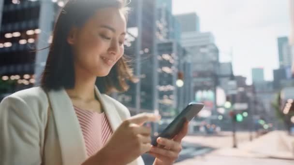 Japansk kvindelig bruger Smartphone på City Street – Stock-video